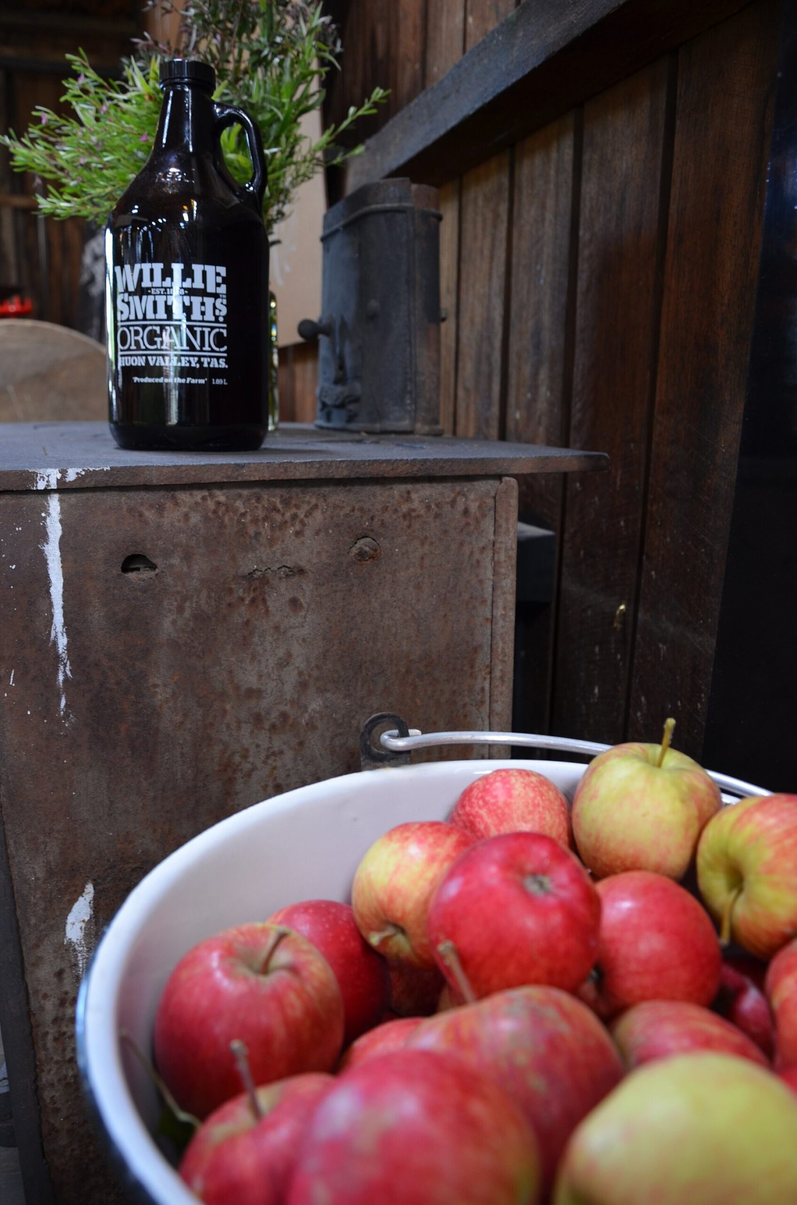 Ladling hot spiked apple cider from a pot into a rustic mug