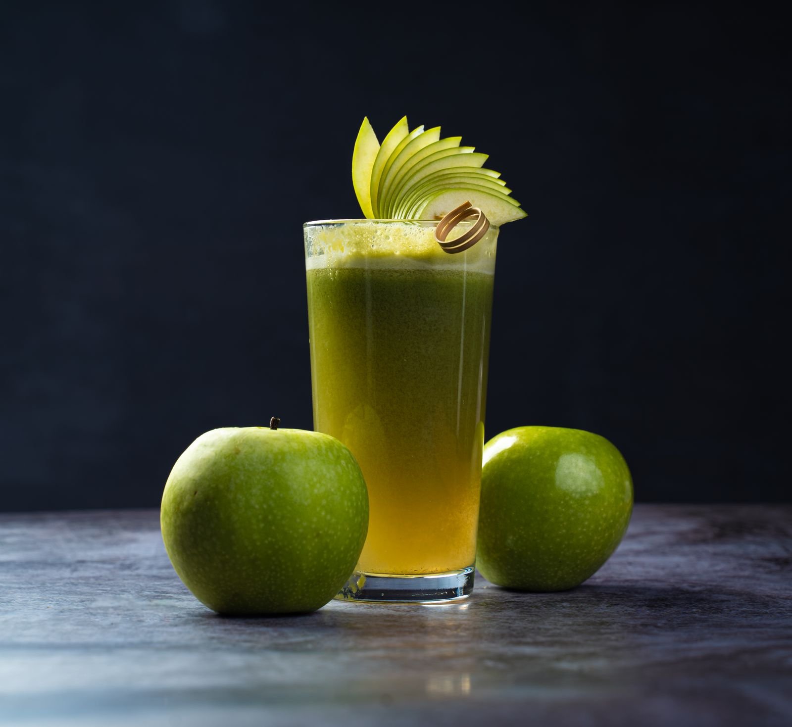 Glass jug of fresh apple juice poured beside the baking ingredients