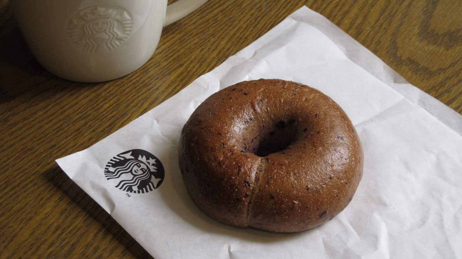 Plain ring-shaped bagels rising on a baking tray before baking