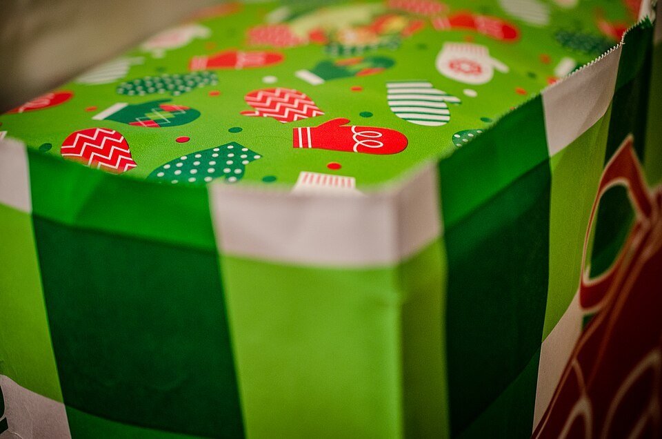 A dad smiling as he opens a gift surrounded by family