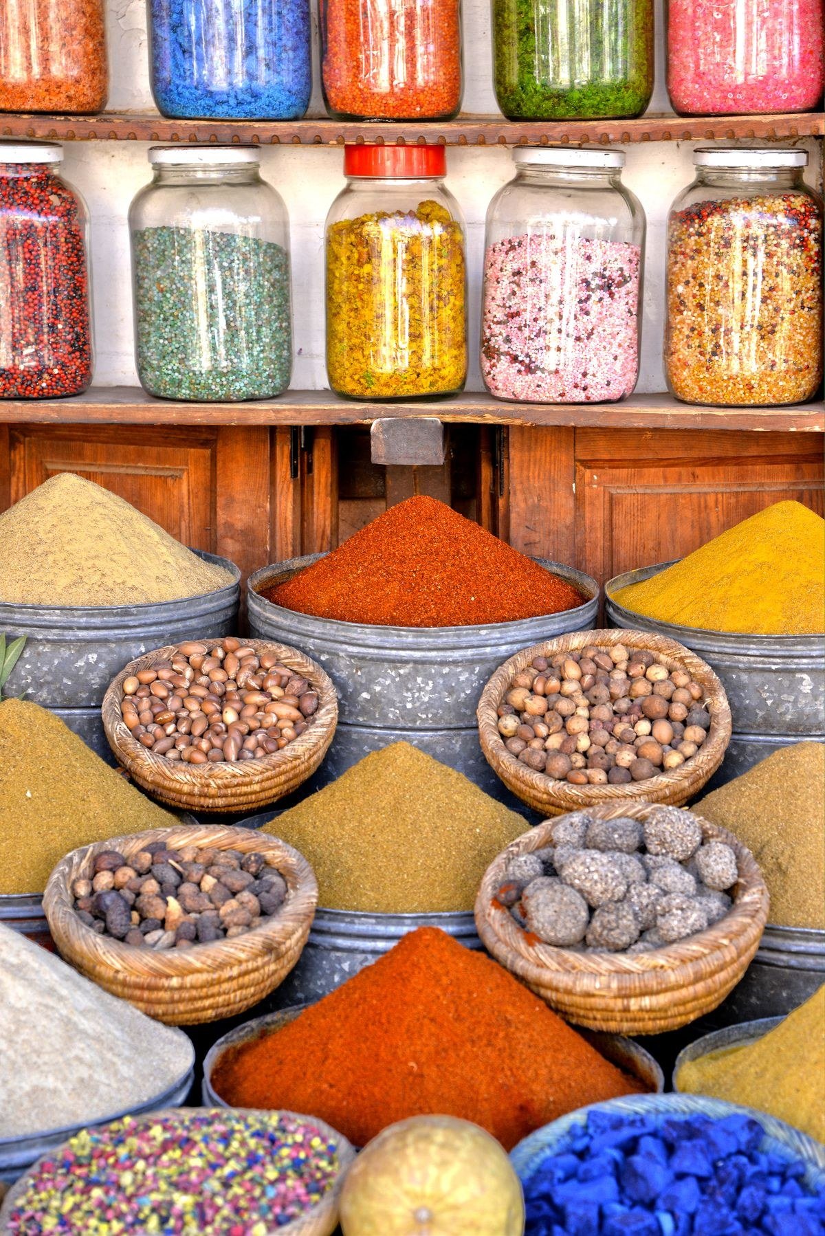 Homemade spice blends in glass jars next to store-bought spice containers