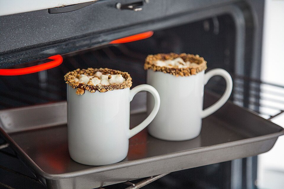 Mugs, hot chocolate mix, and marshmallows arranged for a cozy drink