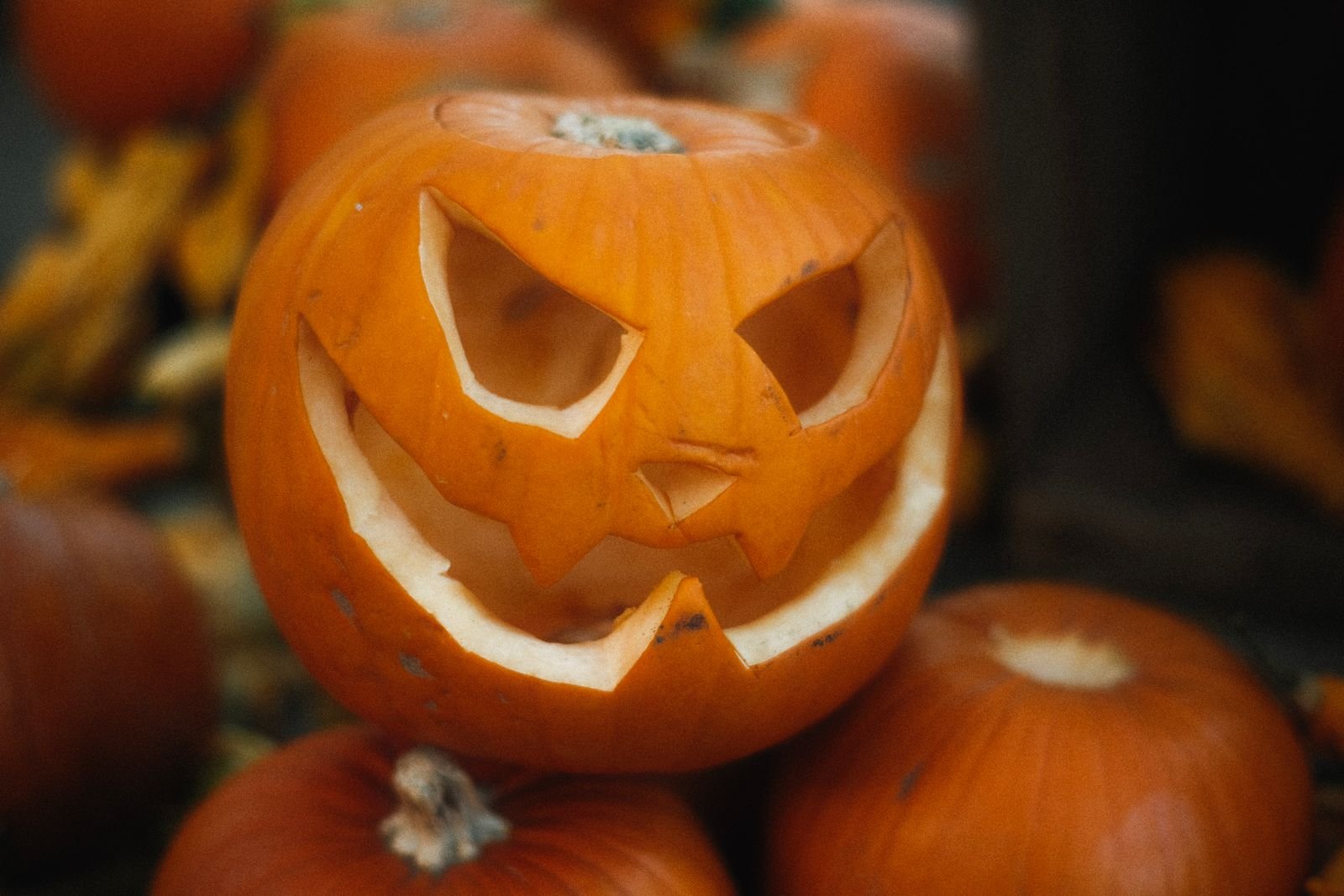 Carved Halloween pumpkin glowing beside a dinner table setting