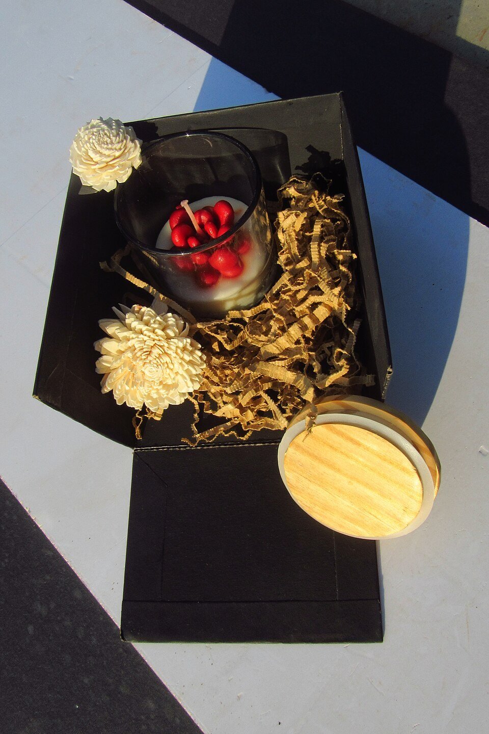 Hand cream, lip balm, and a scarf arranged for winter comfort