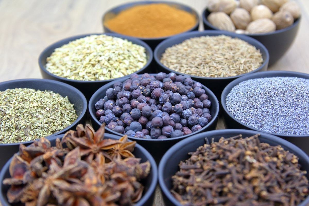 Measuring spoons and a kitchen scale with bulk spices for large batch blending