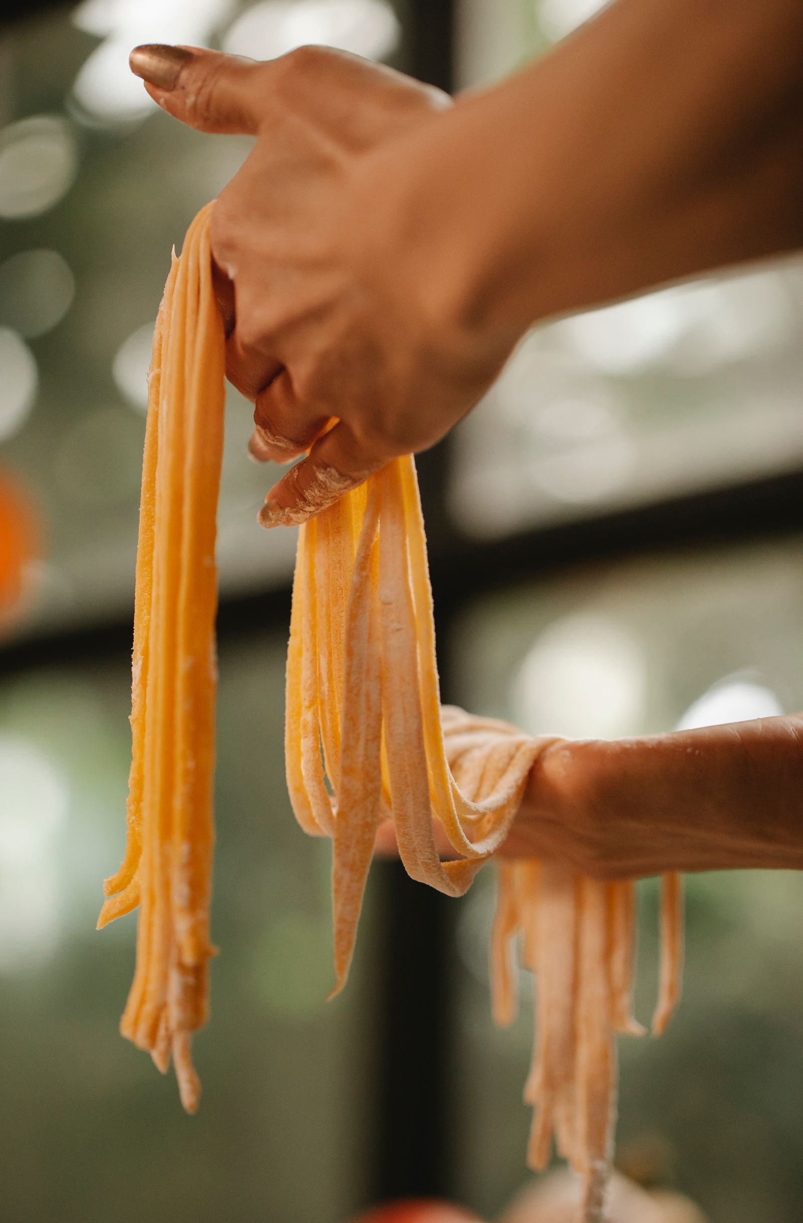 Woman demonstrating fresh homemade pasta dough ready for cooking