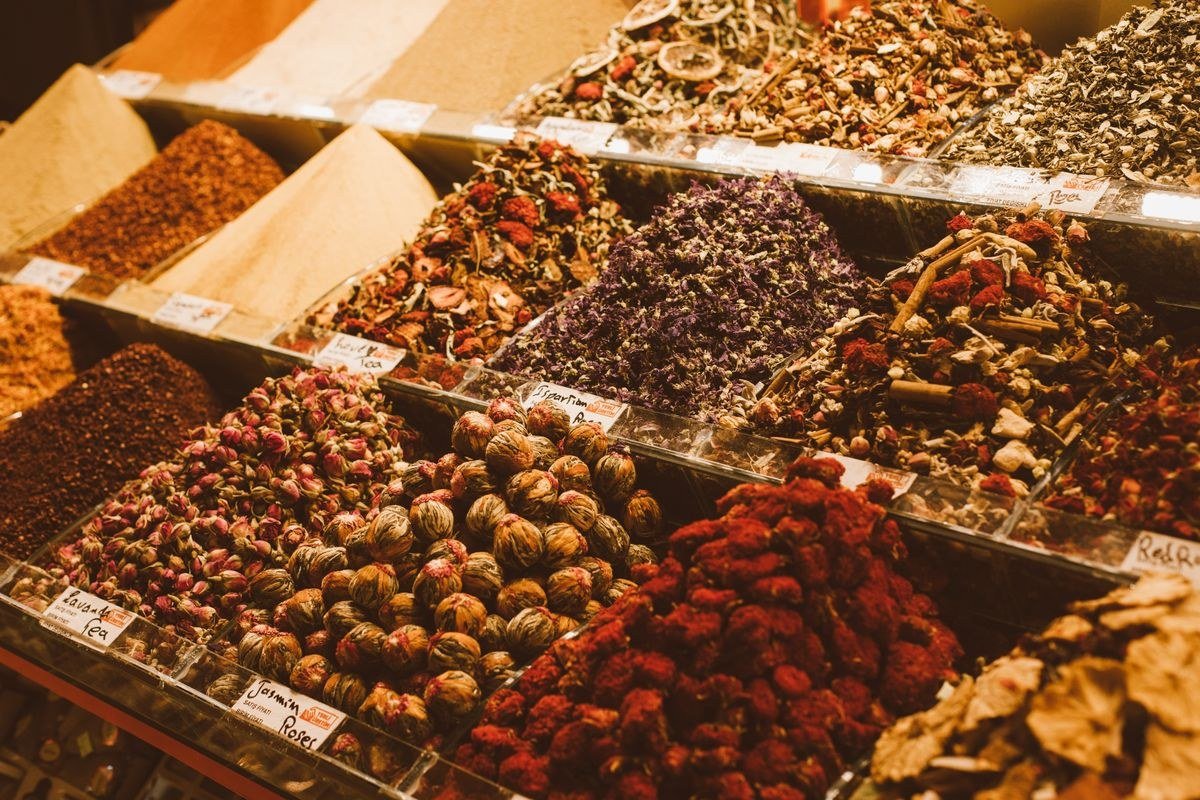Cook creating a custom signature spice blend with tasting spoons