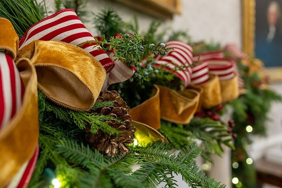 A classic evergreen garland with pinecones on a mantle