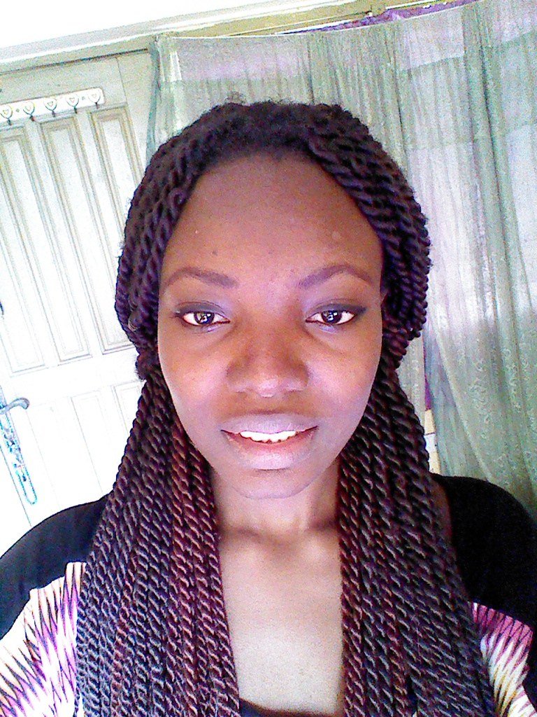 Mostly pink knotless braids with black roots showing