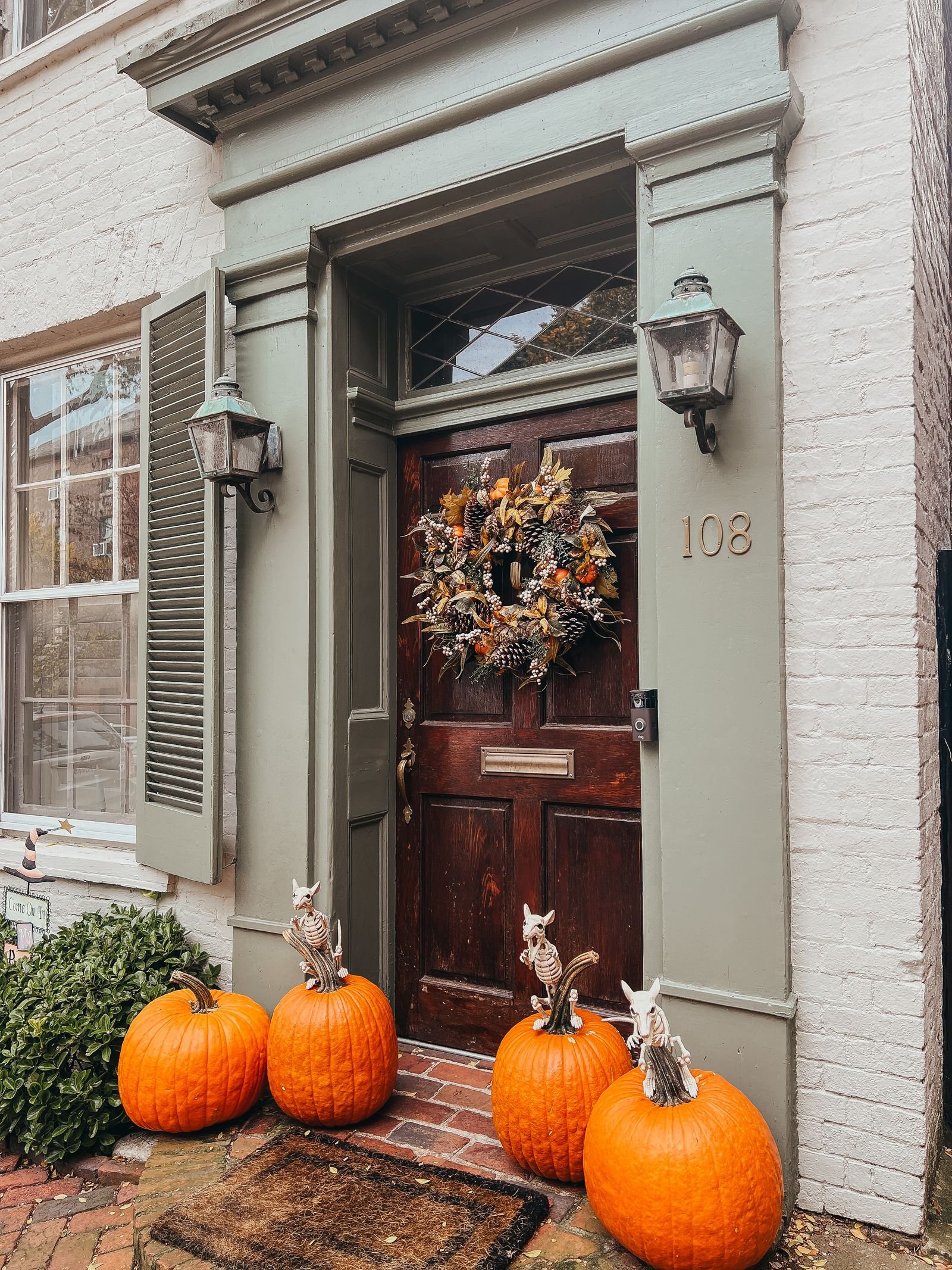 Elegant doorway adorned with pumpkins and an autumn wreath for Halloween
