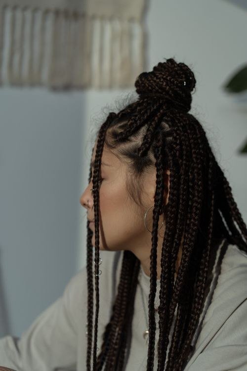 Black and pink knotless braids styled into a high bun