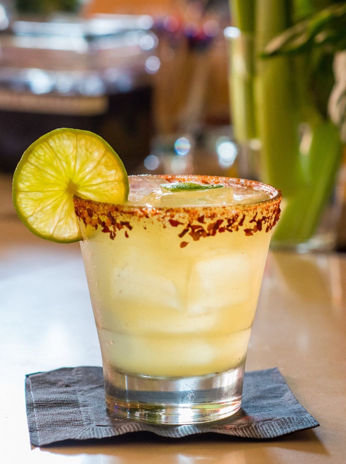 Midnight margarita cocktail with deep black color and glowing bar background
