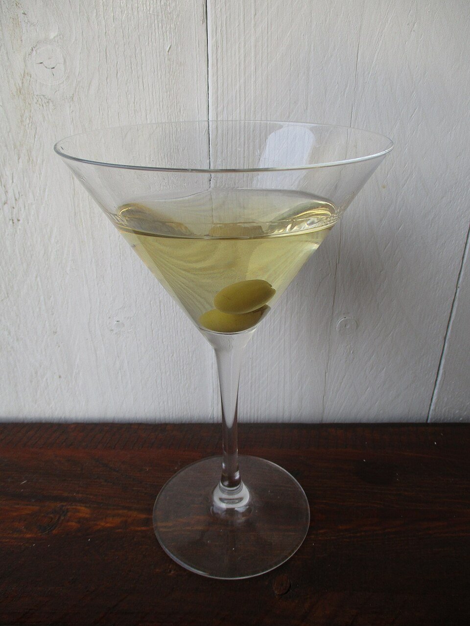 A pomegranate martini with fruit seeds garnishing the glass