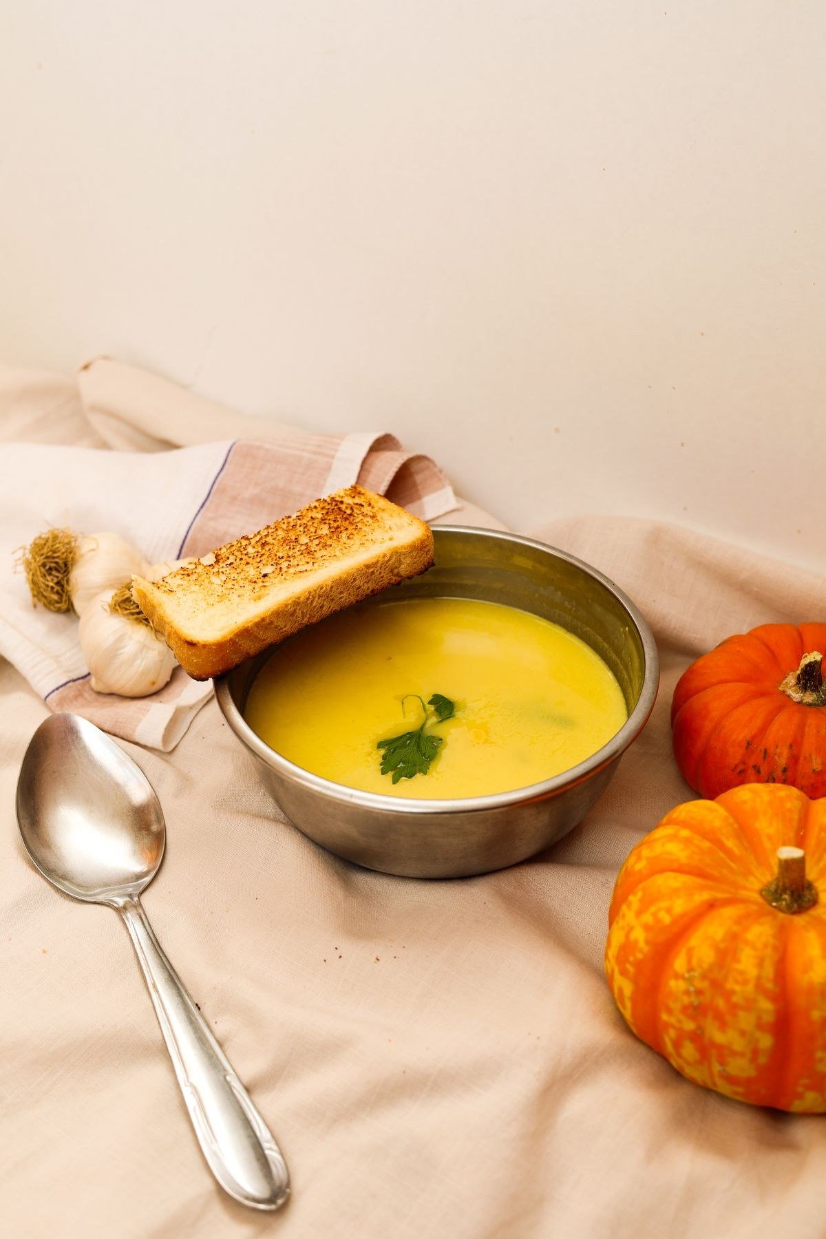 Adding stock and cream to pumpkin soup