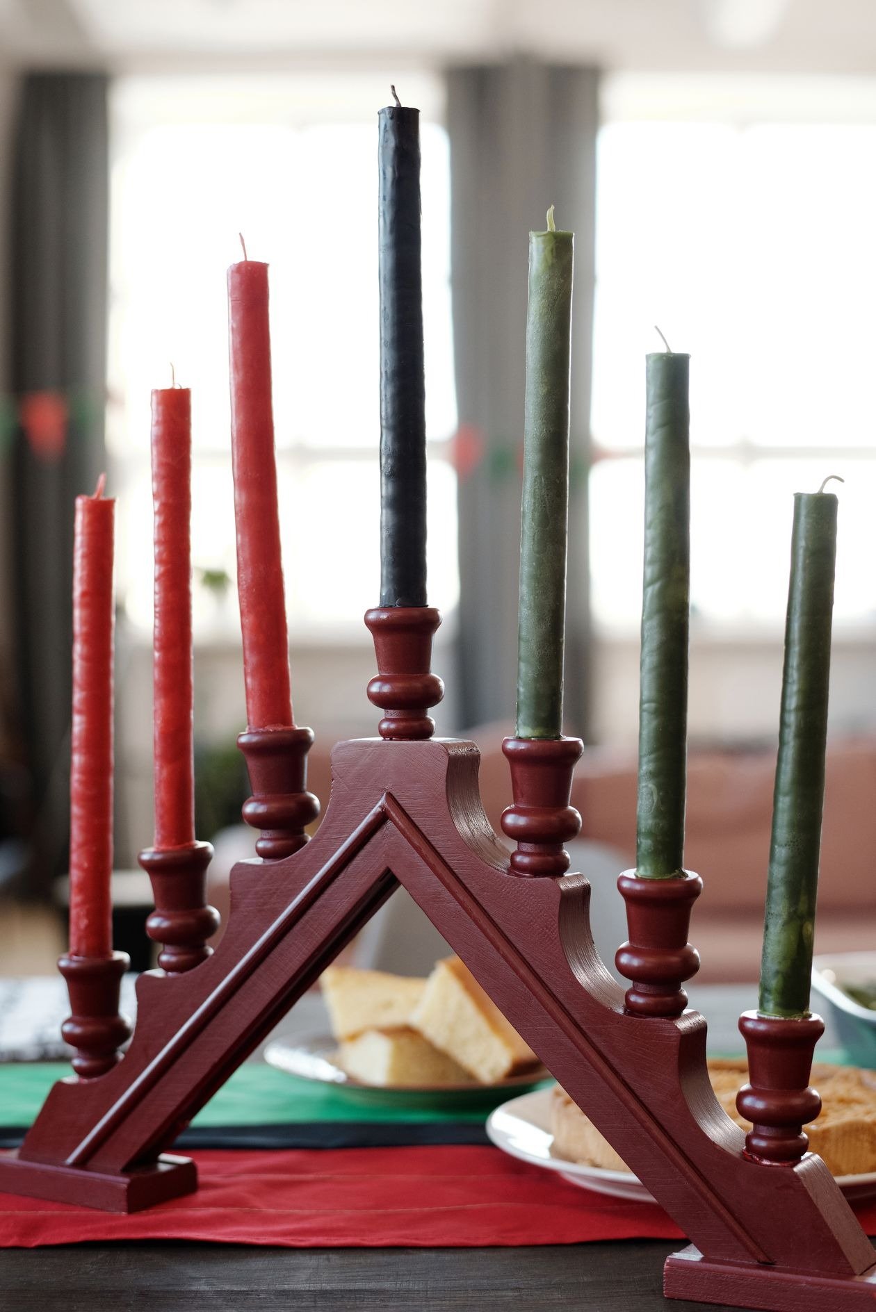 Family learning about Kwanzaa symbols beside a decorated table