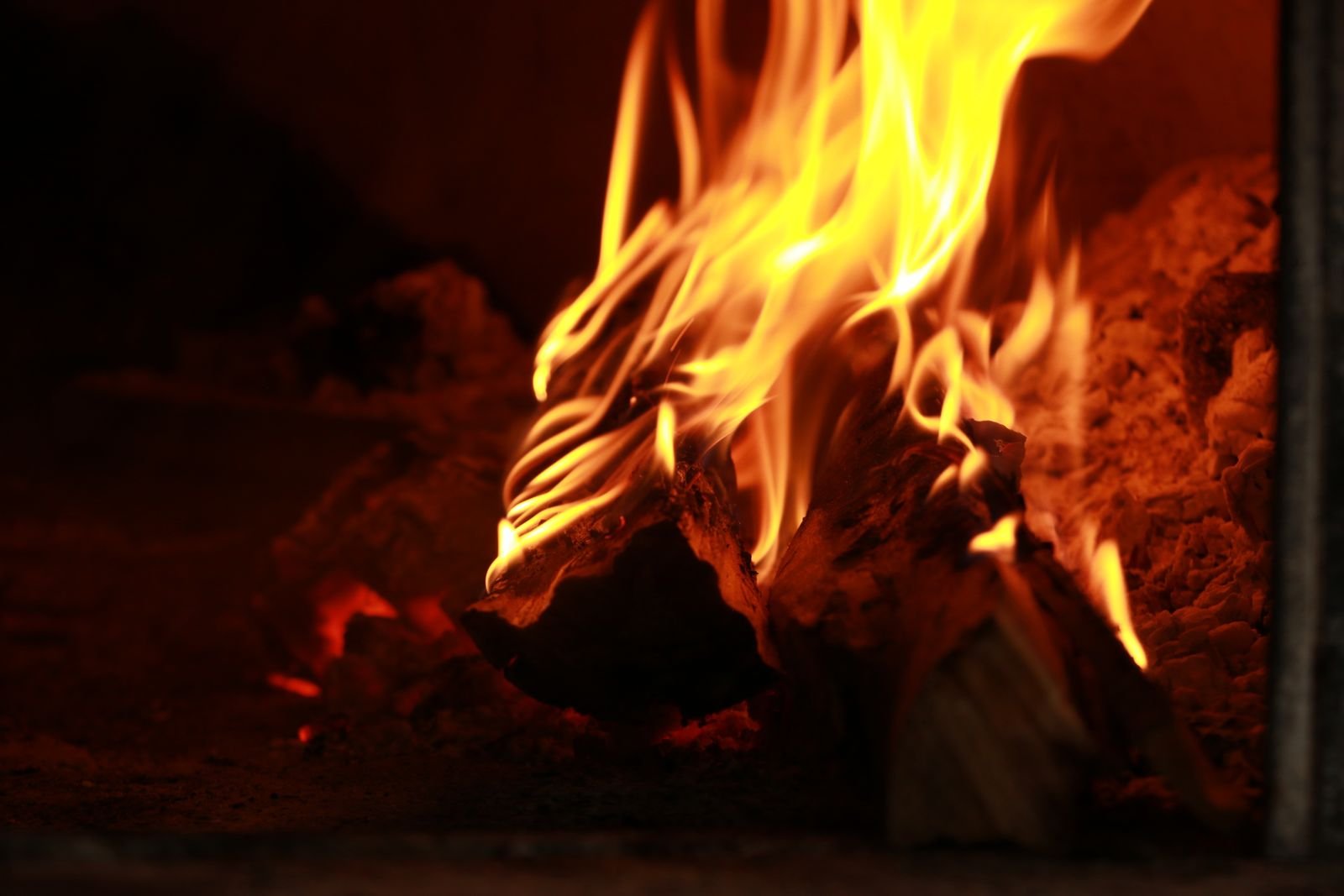 Bright orange flames dancing against a dark evening sky