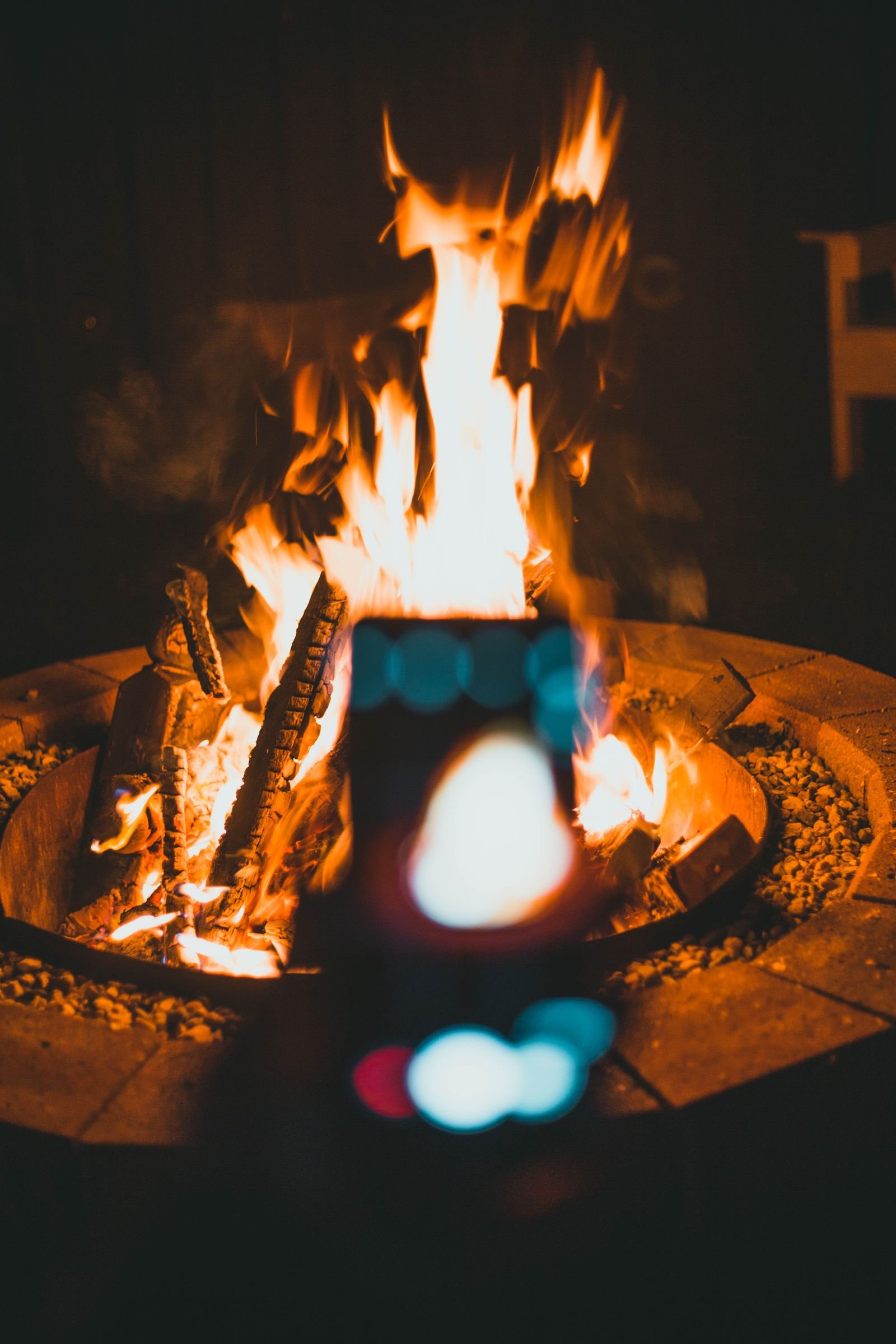 A warm campfire burning brightly among logs and stones
