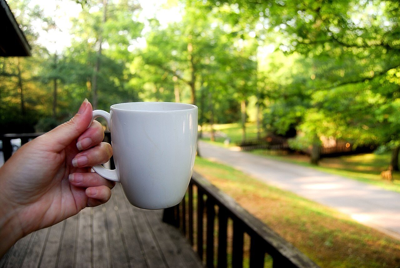 Mug of coffee held outdoors