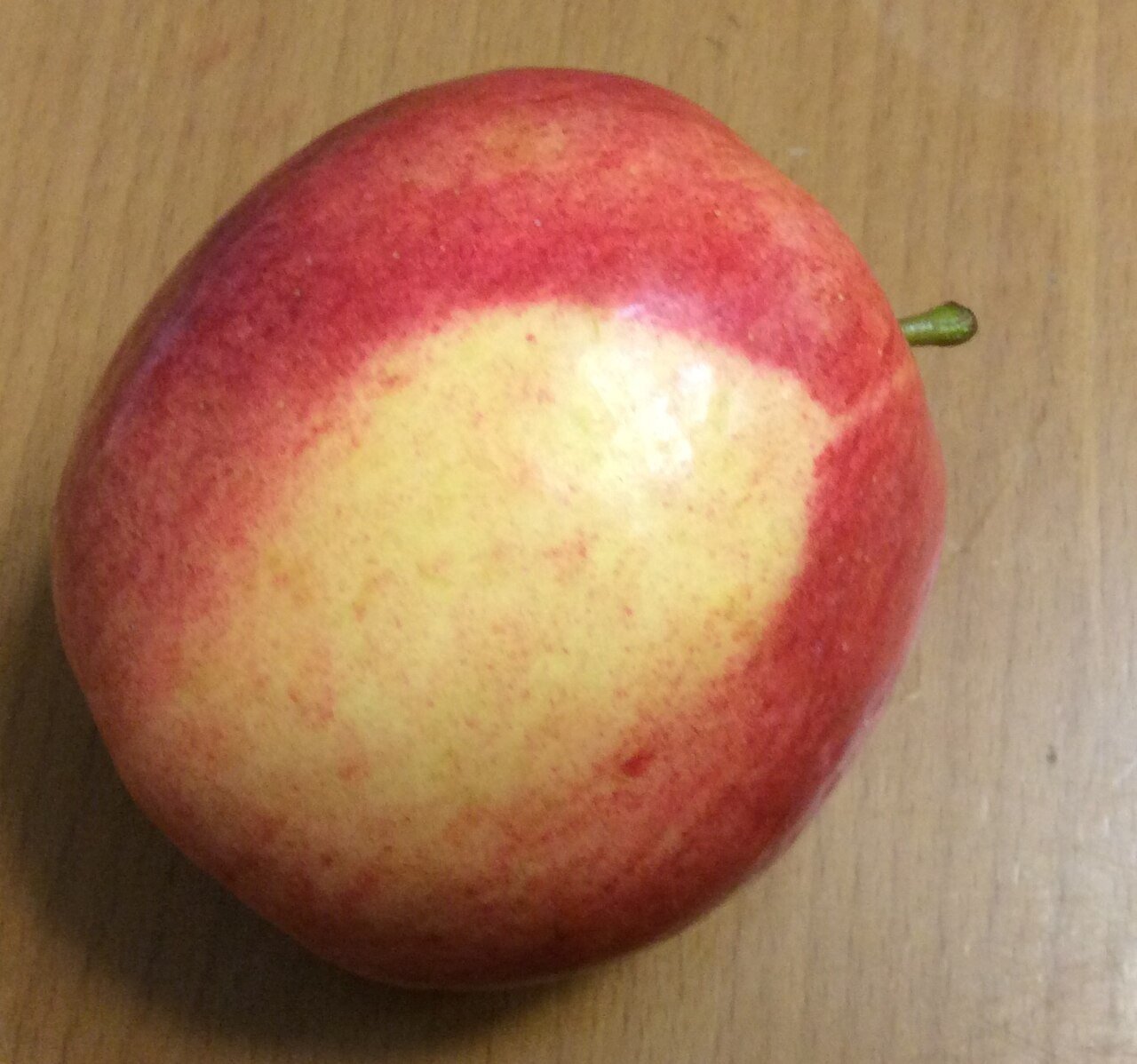 Single red apple on a wooden table