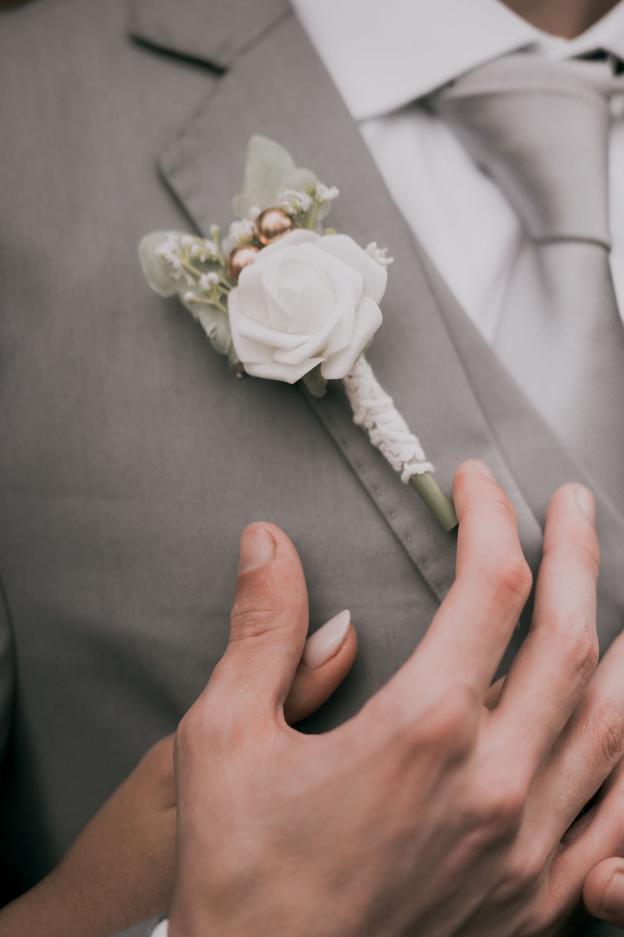 Man checking brooch size on suit lapel in mirror