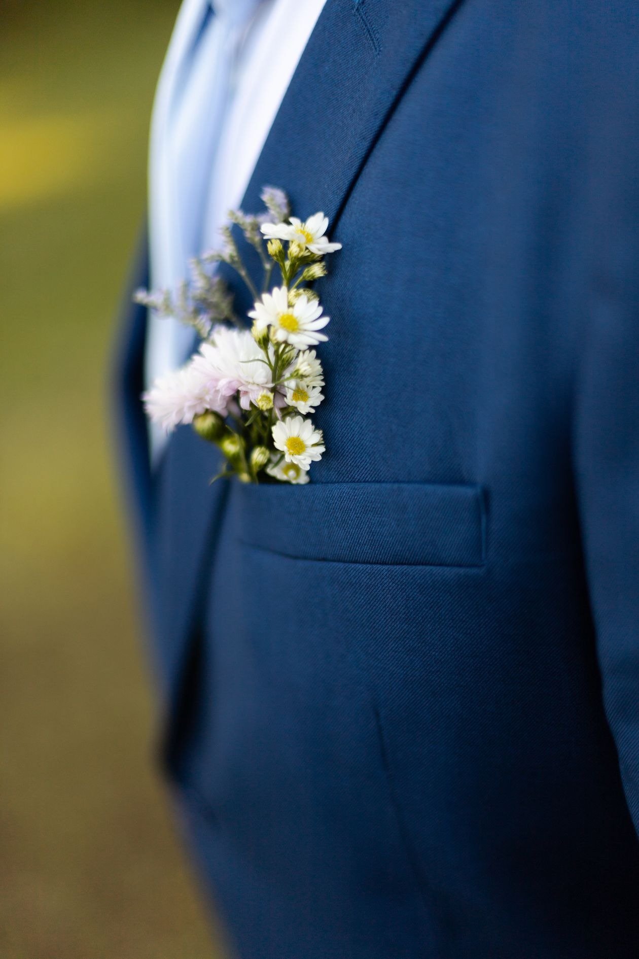 Floral brooch on grooms suit at wedding