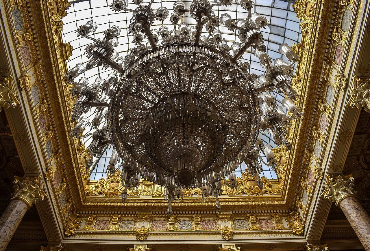 Grand crystal chandelier above a palace staircase