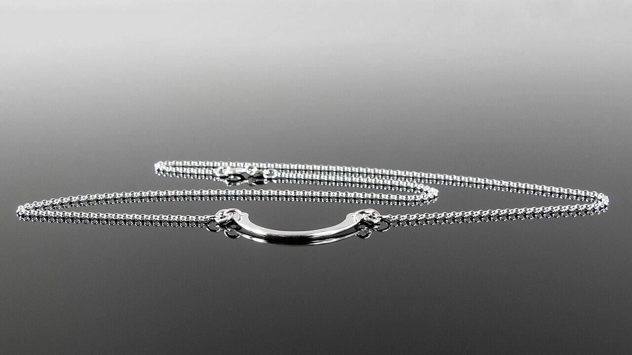 Silver necklace on a plain background