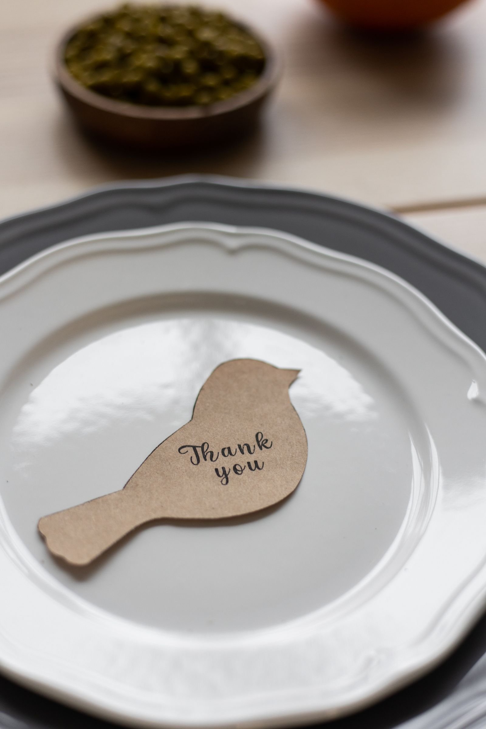 Bird-shaped Thank You place card glowing in warm candlelight