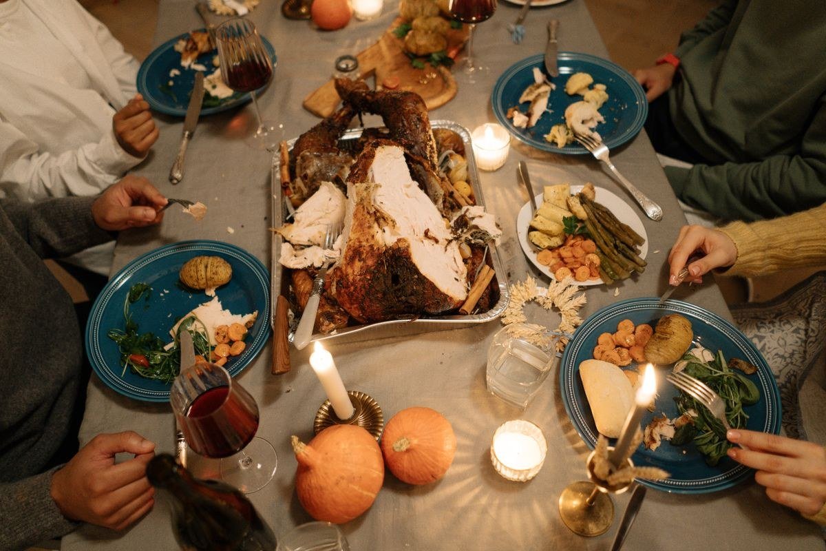 Kids making turkey crafts with paper, feathers, and glue at the table