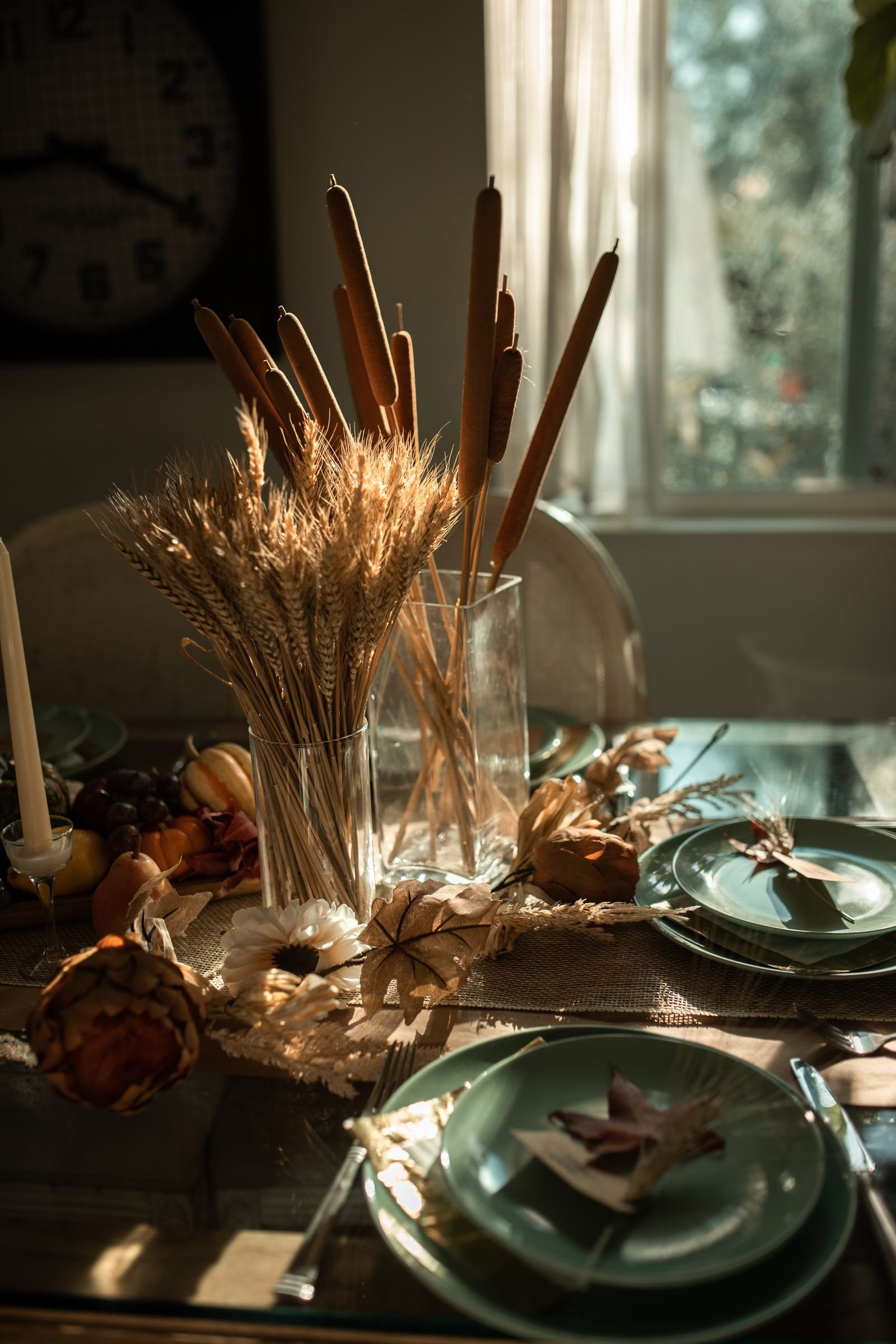 Wheat and cattails centrepiece glowing in warm golden table light