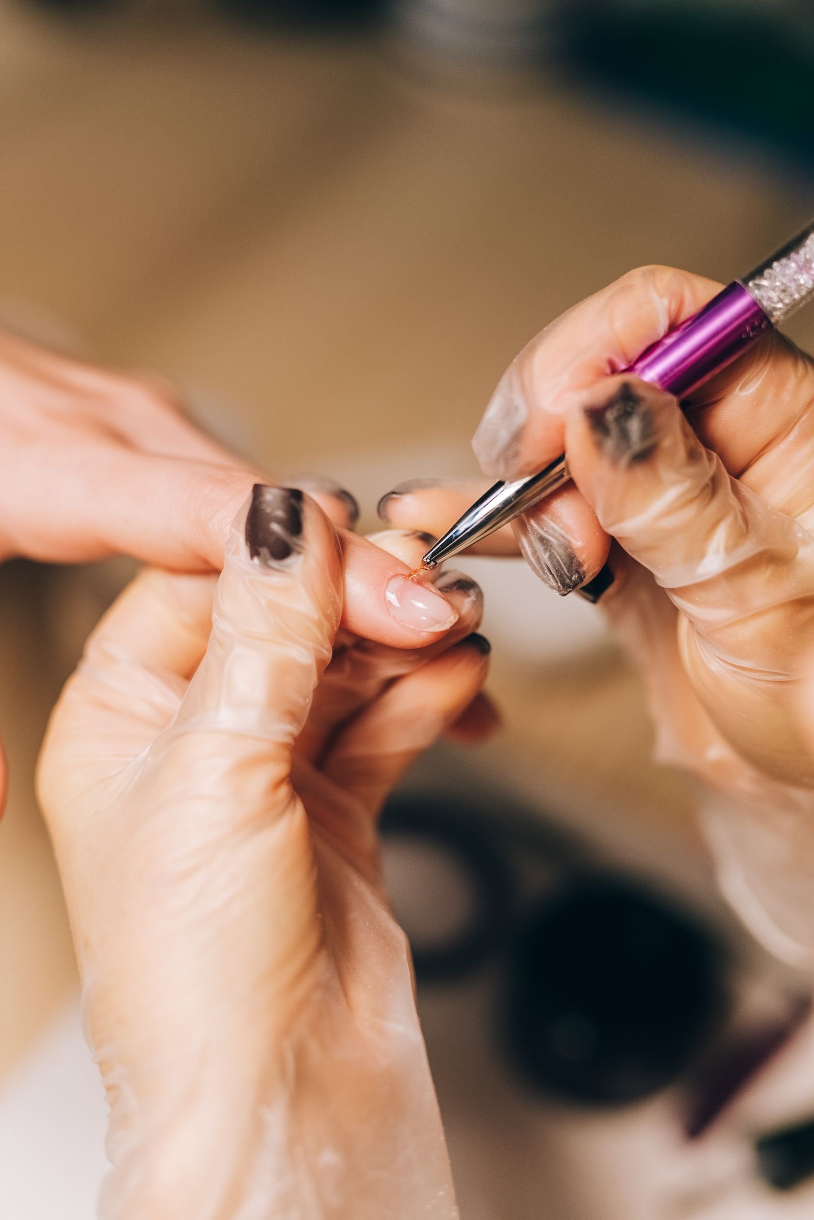 Manicurist applying polish during a professional chrome nail treatment