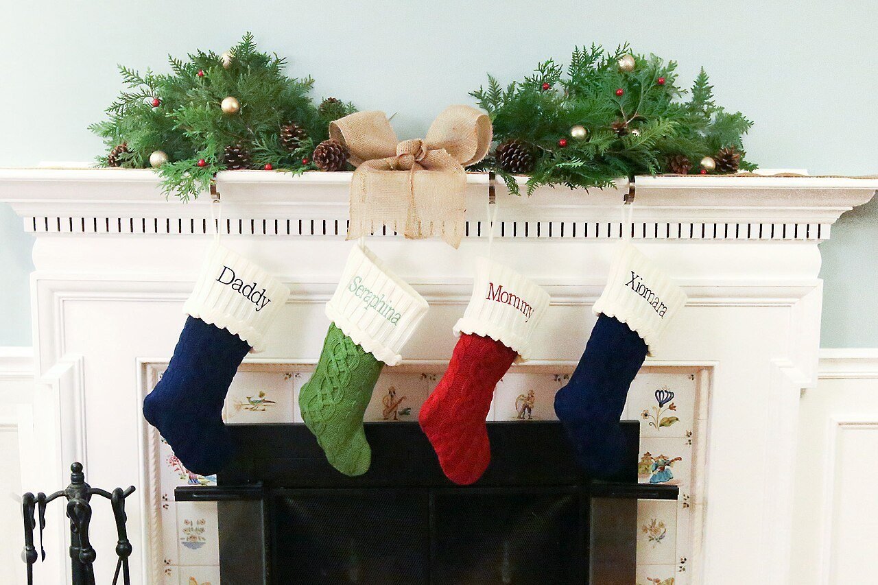 Christmas mantel with pine centerpiece, holly and ribbon