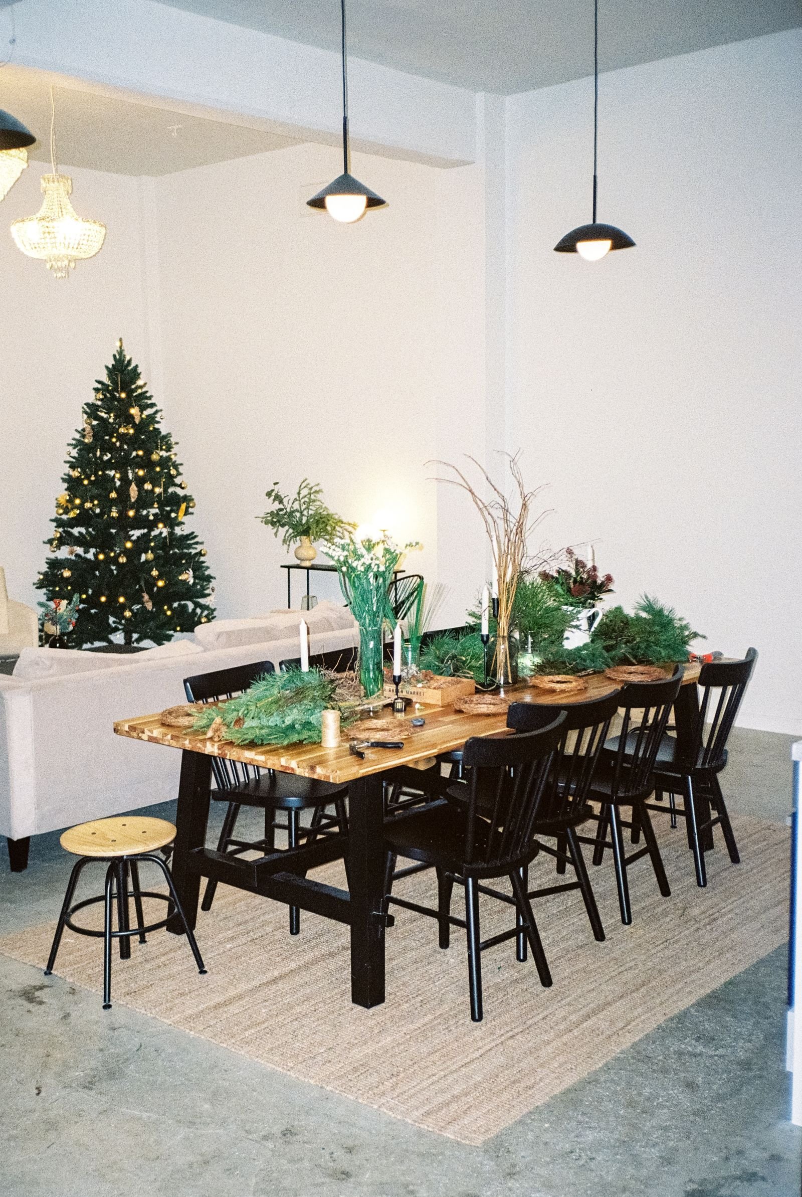 Dining room with Christmas tree glowing behind the festive wooden table