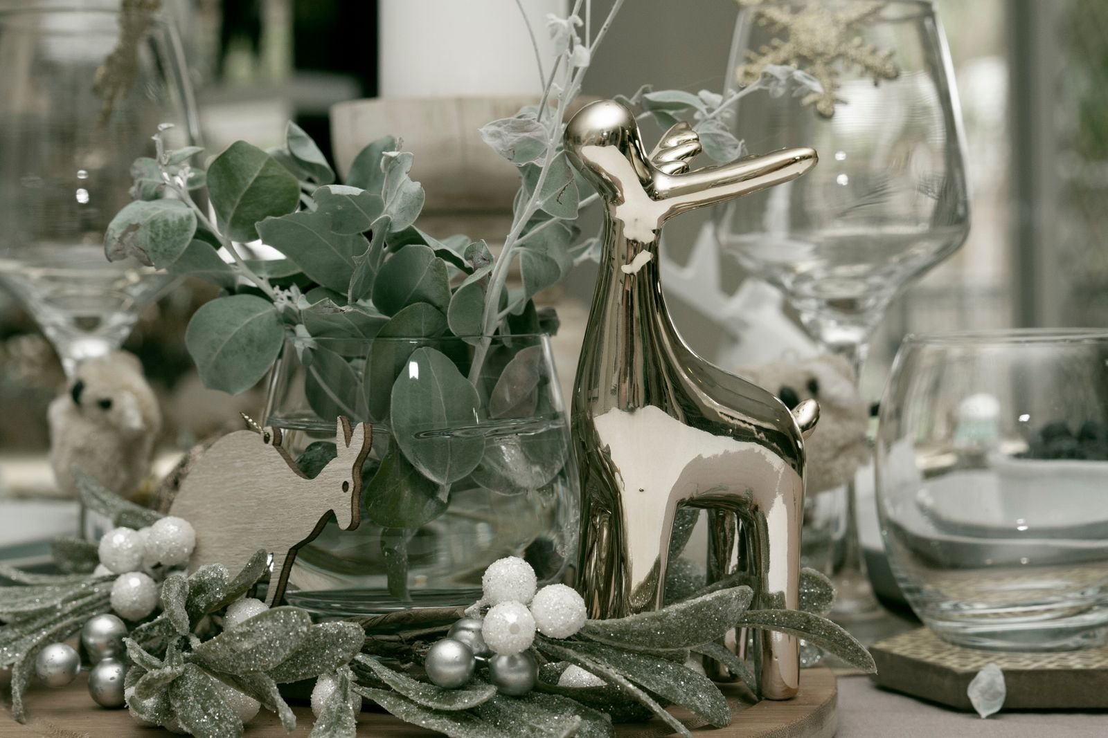 Metallic deer figurine nestled in greenery as a transitional centrepiece
