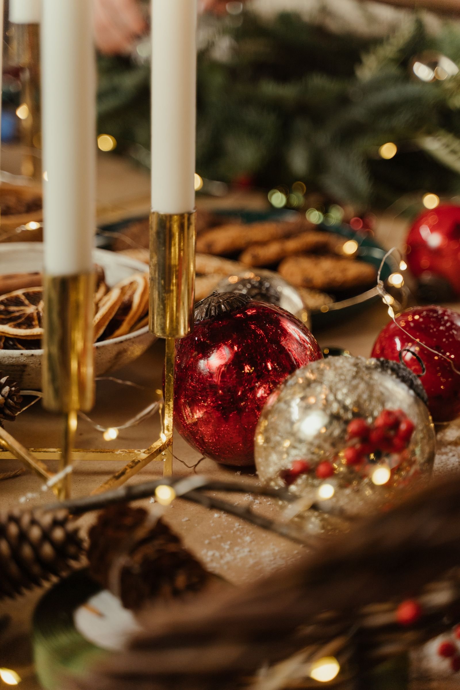 Christmas baubles, candles and cookies arranged for a festive atmosphere