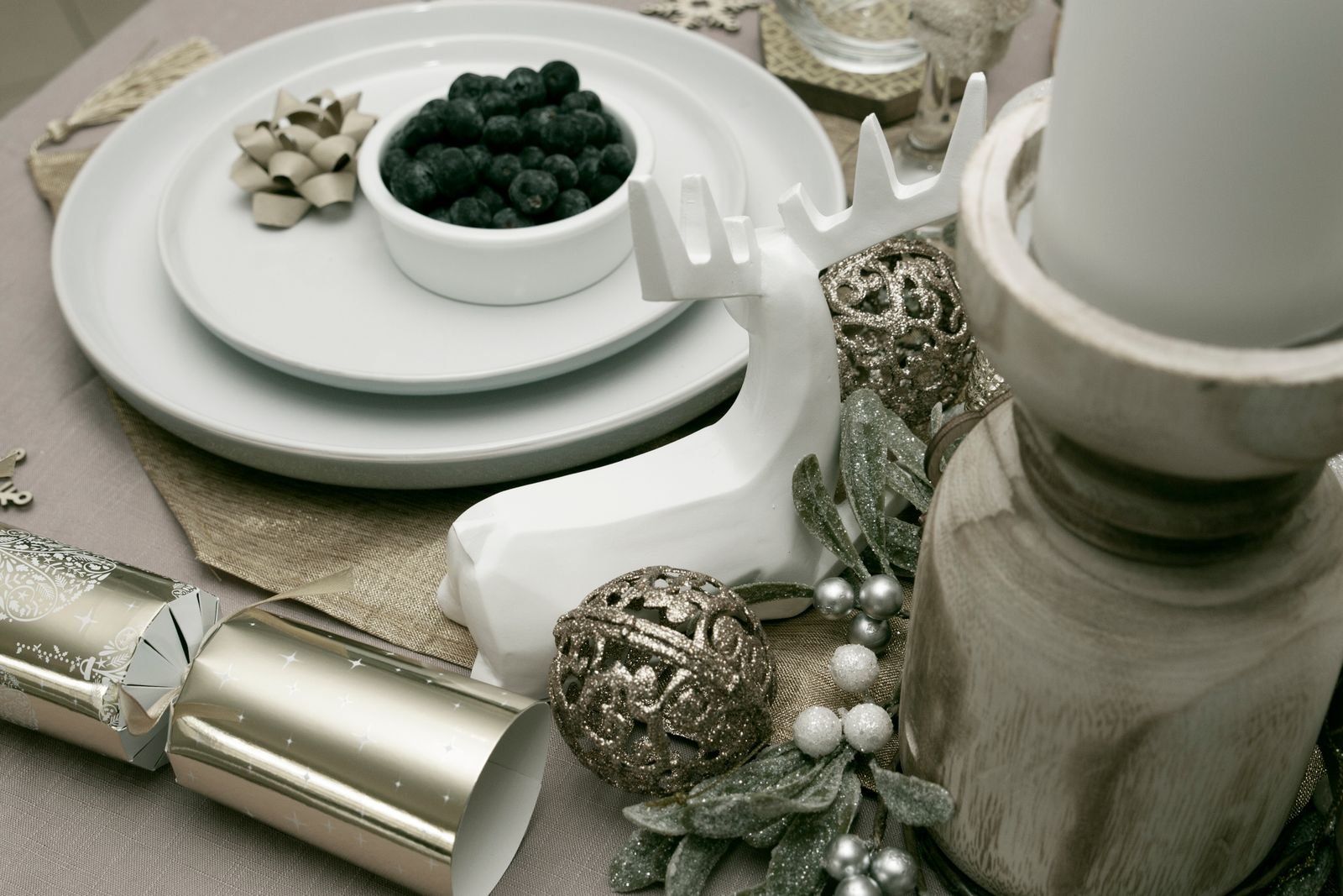 Holiday table decorated with reindeer, red berries and festive greenery