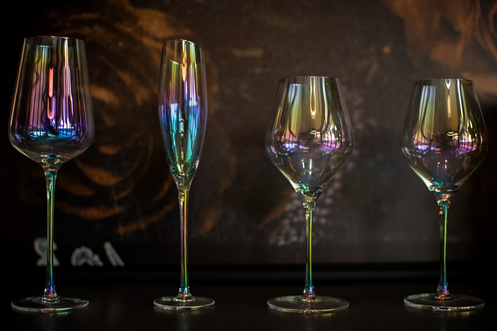 Holographic wine glasses reflecting colourful light at a wedding