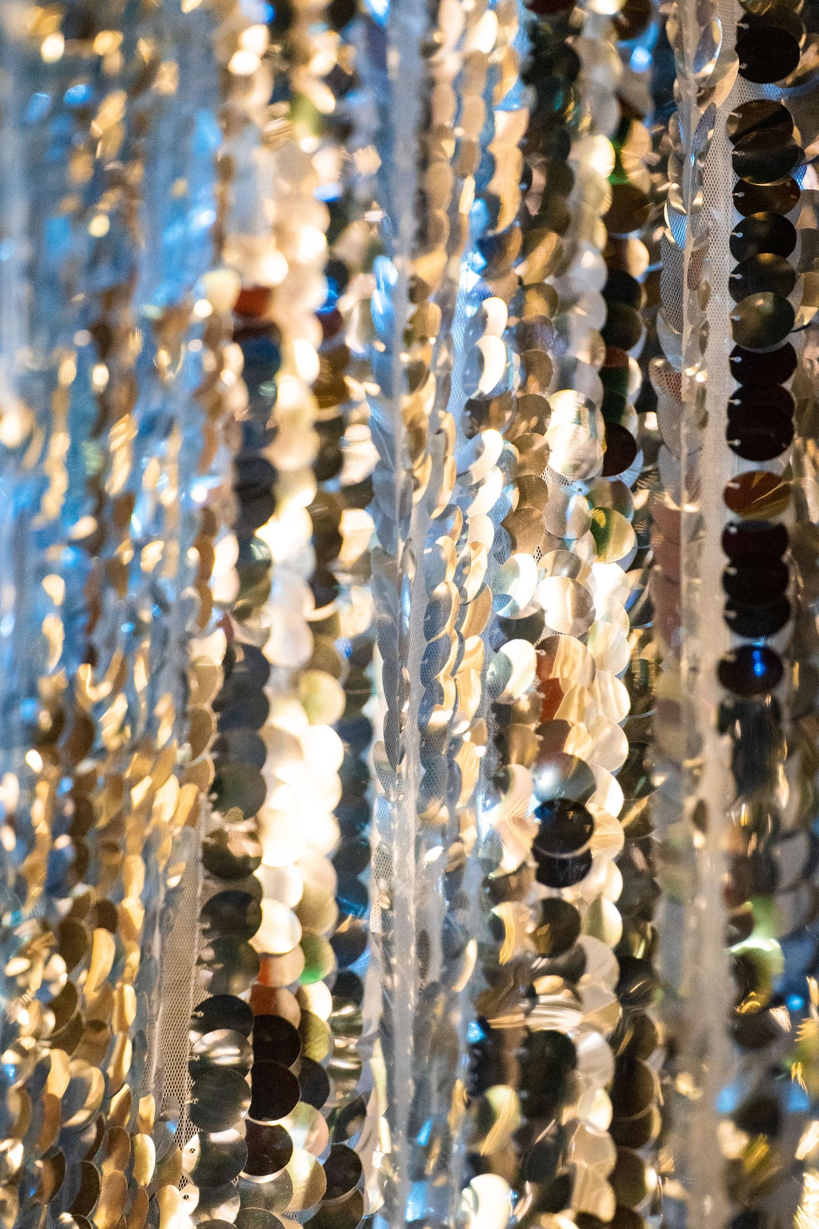 Shiny metallic sequins draped in light creating a sparkling effect