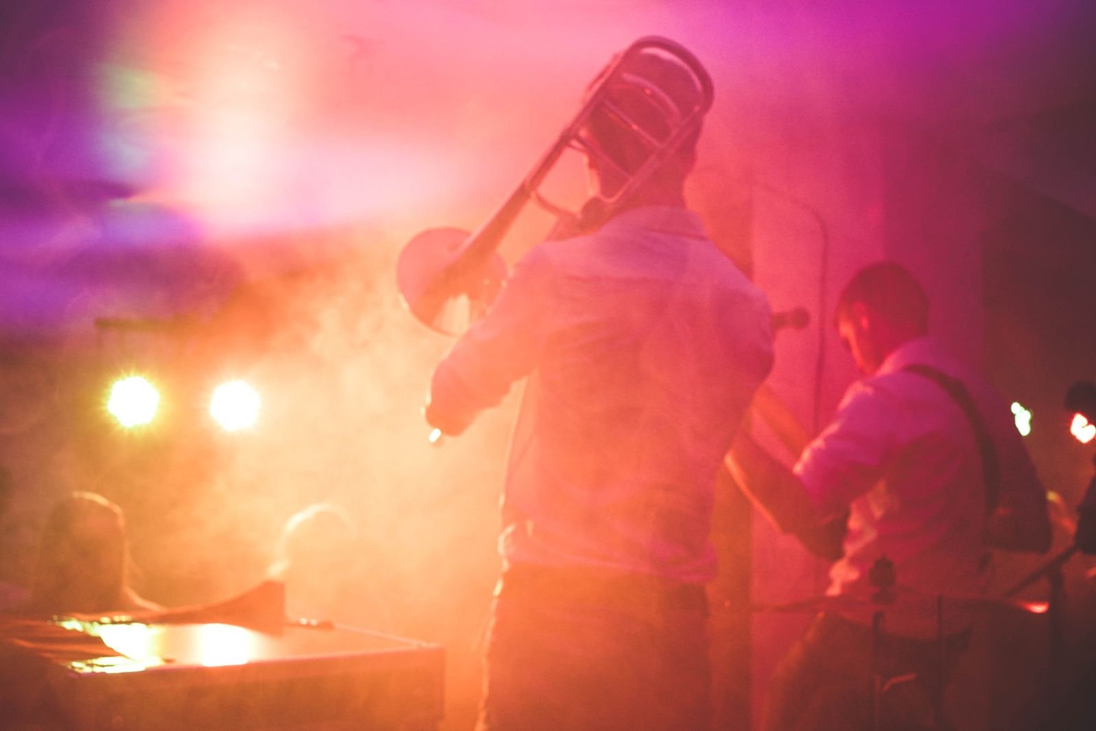Trombone player performing live on stage in a nightclub setting