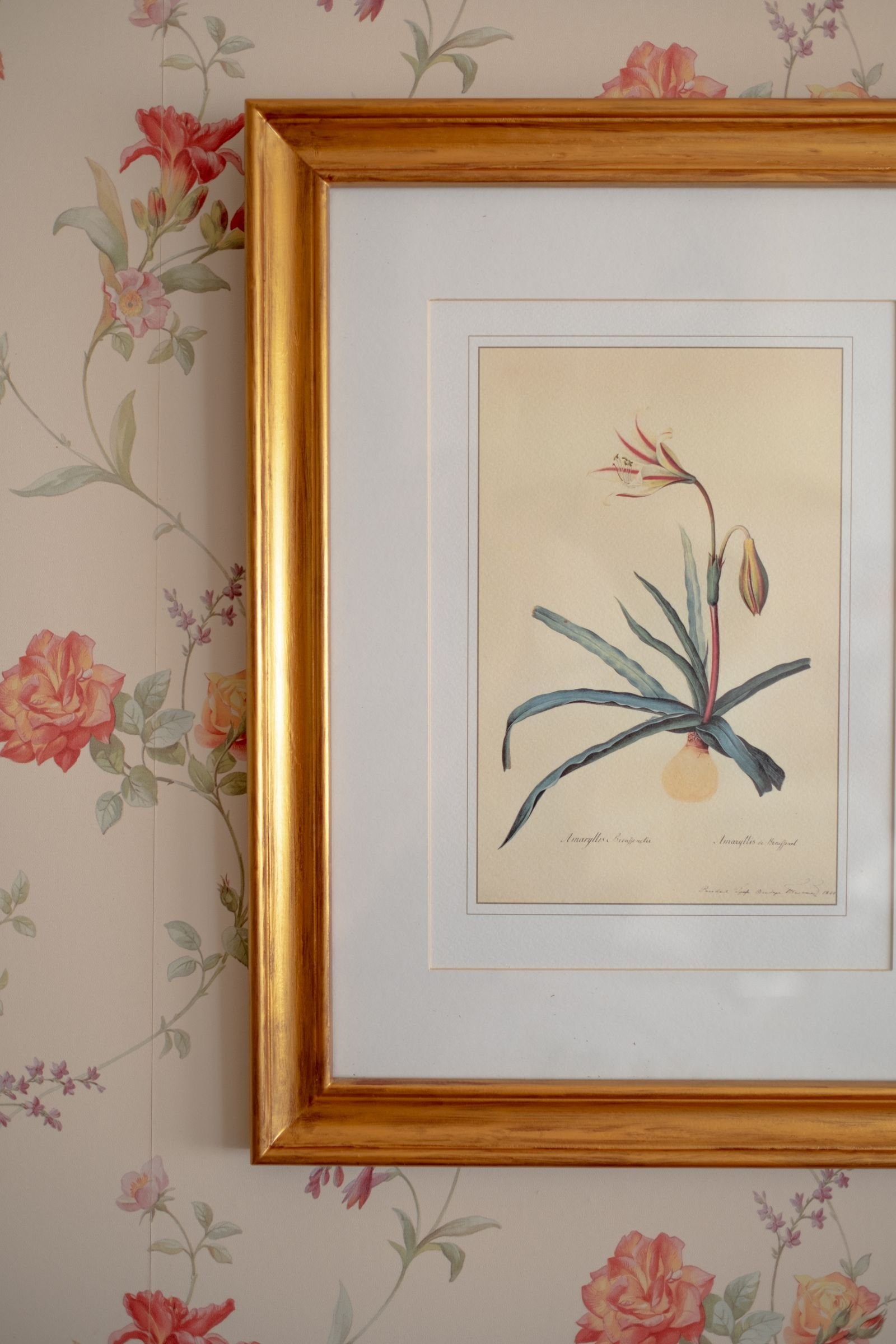 Vintage frame with floral art against patterned wallpaper