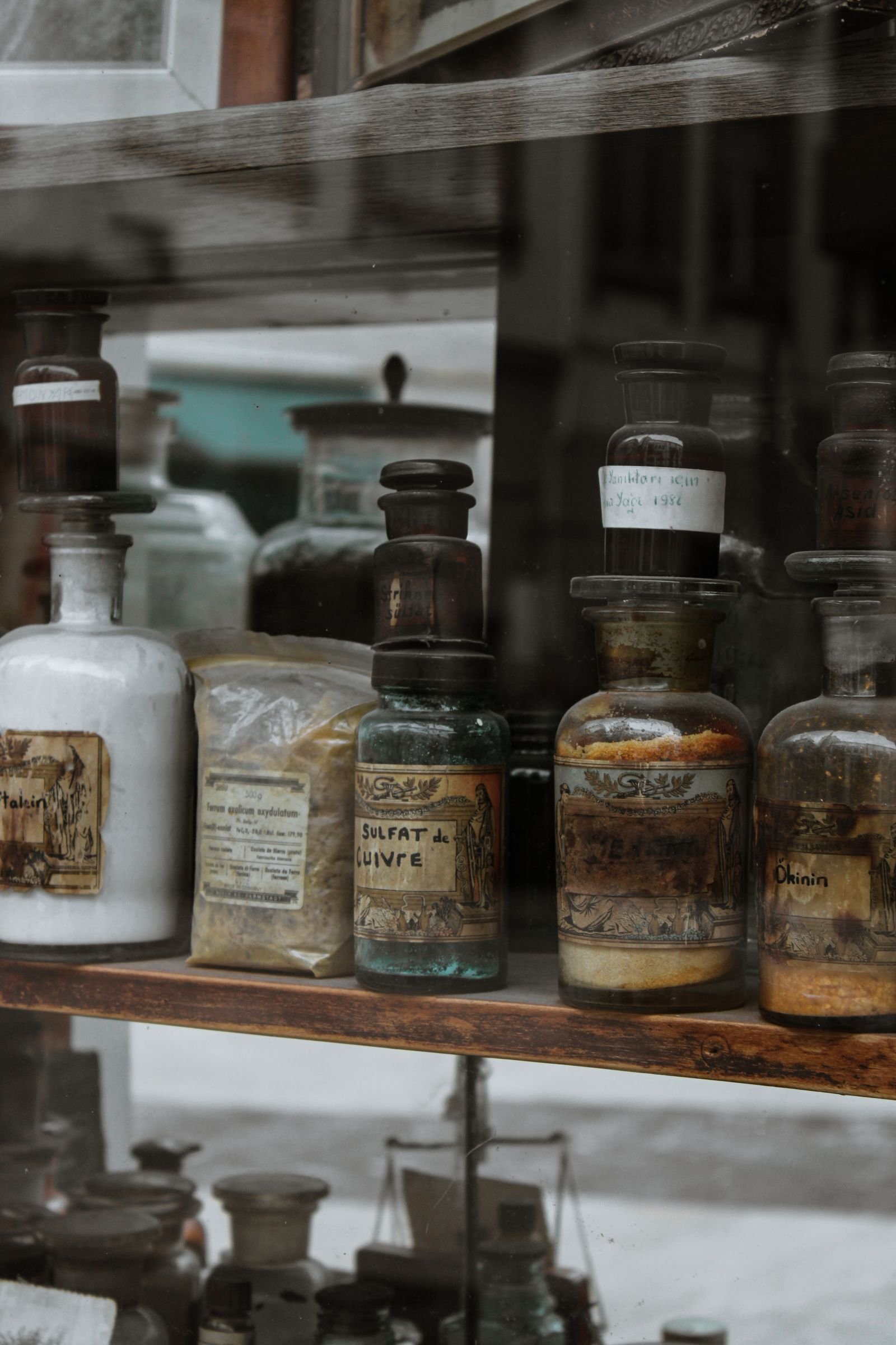 Apothecary bottles and jars arranged on a rustic wooden shelf