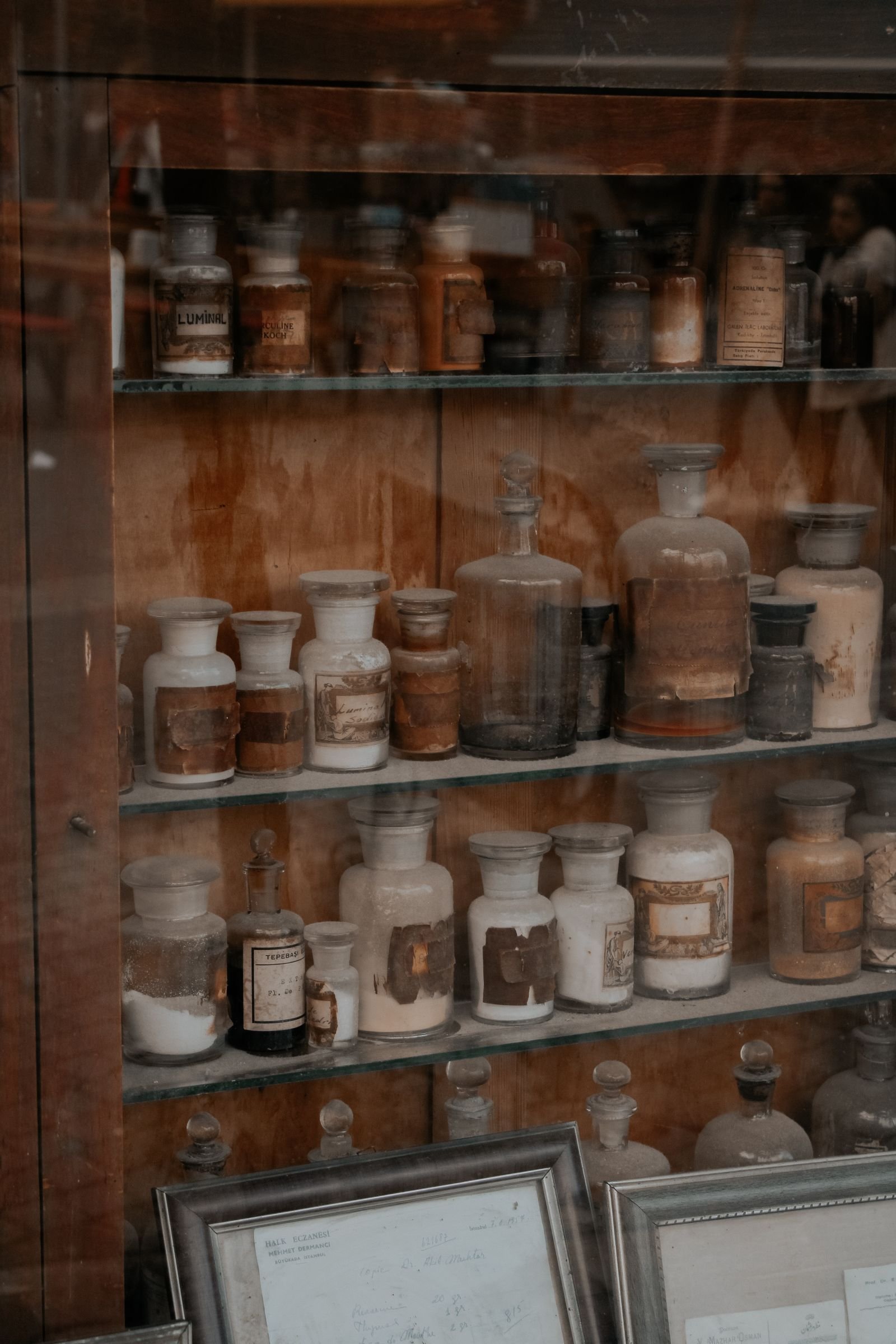 Apothecary bottles displayed in an antique wooden cabinet